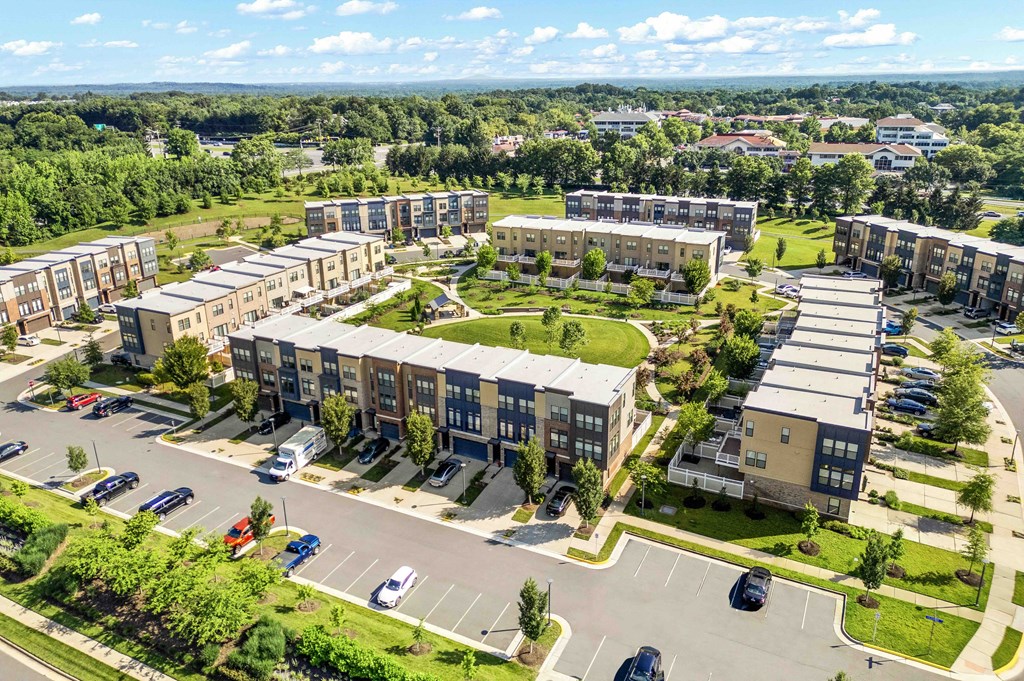 A large apartment complex with a parking lot in front.