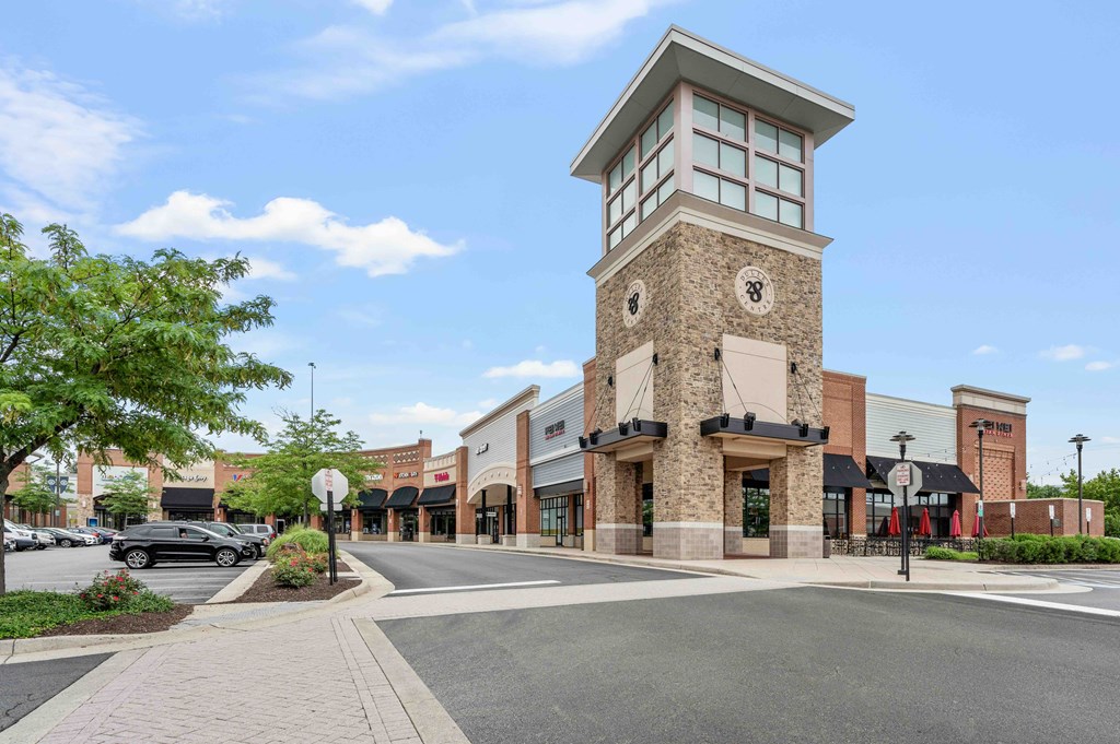 A large building with a clock tower is situated in the middle of a street.