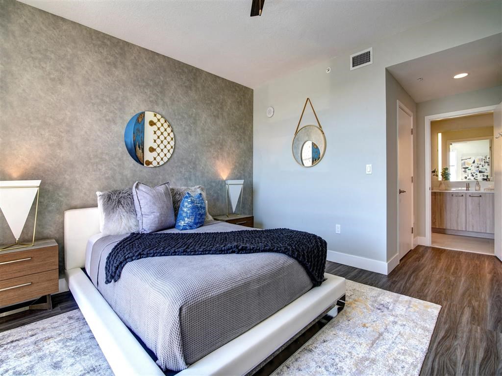 A bedroom with a bed, a dresser, and a mirror on the wall.