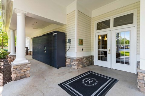 A black and white entrance mat with a letter R on it.