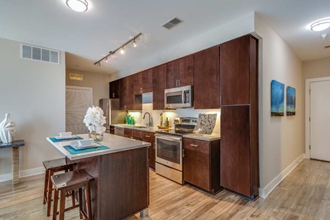 A kitchen with brown cabinets and a wooden island.