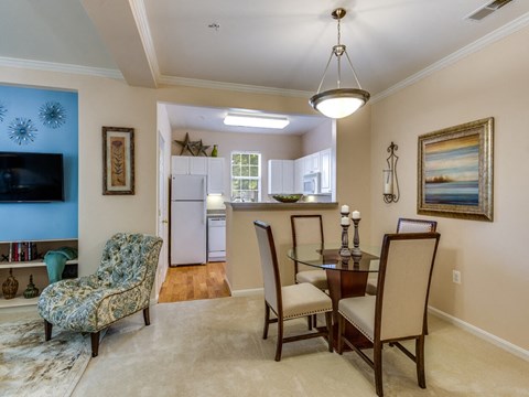 a living room and dining room with a table and chairs