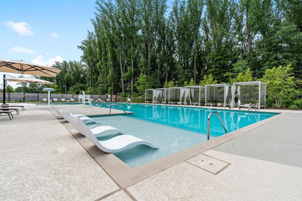 a swimming pool with two lounge chairs next to it