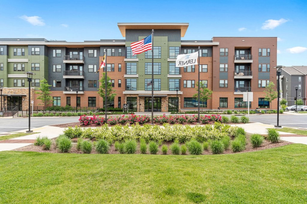 an apartment building with an flag in front of a garden