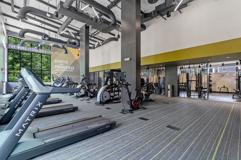 a gym with cardio machines and weights in the lobby of a building