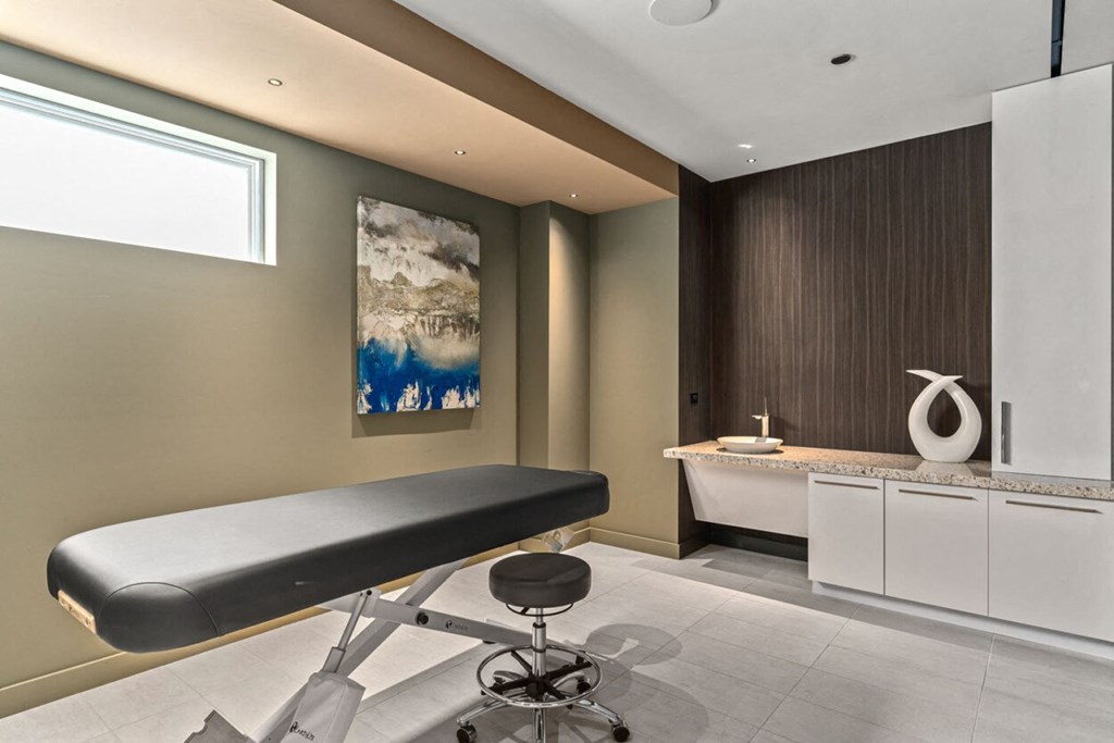 a spa room with a massage table and a sink