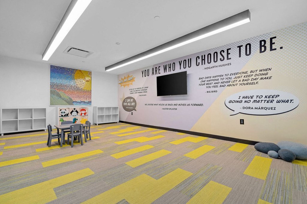 a large room with tables and chairs and a wall saying you are who you choose