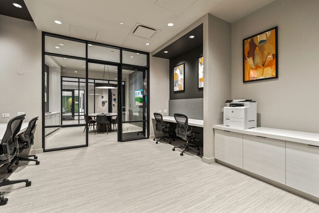 a conference room with glass doors and chairs and a counter with a printer