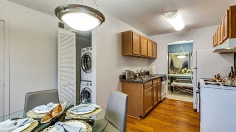 a dining room table and a kitchen with a washing machine