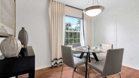 a dining room with a table and chairs and a window