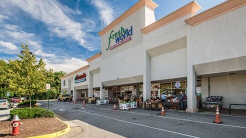 the facade of a grocery store with a parking lot
