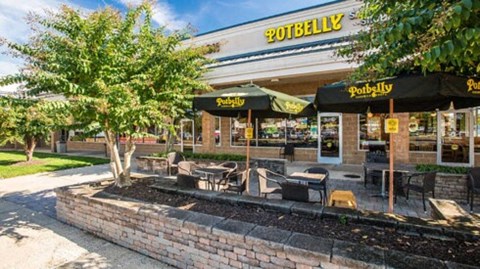 the outside of a restaurant with tables and umbrellas