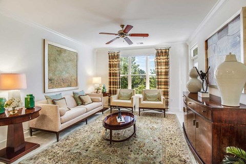 a living room filled with furniture and a ceiling fan