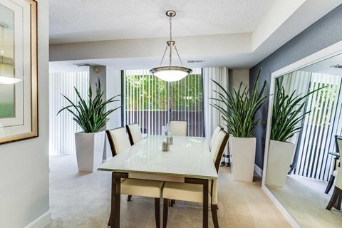 A dining room with a table and chairs.