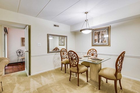 A dining room with a table and chairs.