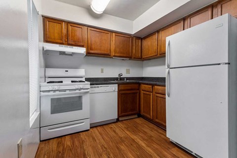a kitchen with white appliances and wooden cabinets