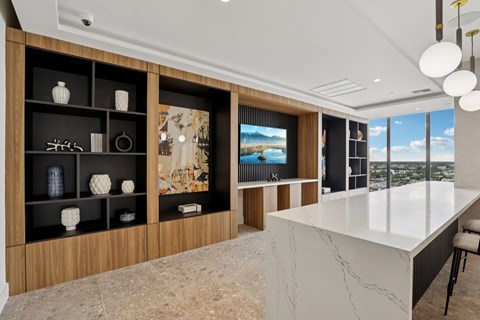 A modern living room with a large white marble table and a wooden cabinet with decorative items.