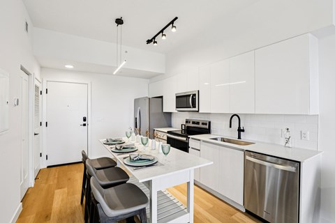 A modern kitchen with white cabinets and a stainless steel dishwasher.