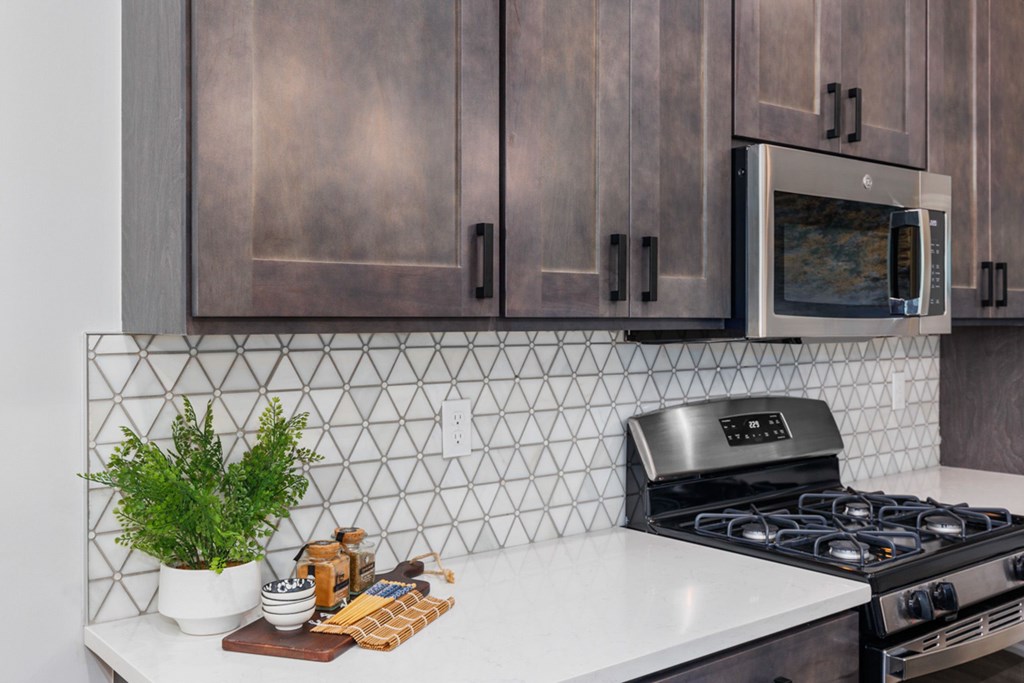 Modern kitchen with stainless steel appliances and white cabinets at Encore at West Valley, Michigan