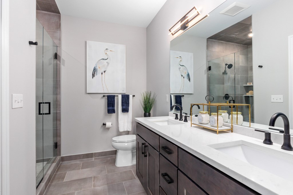 Bathroom with granite counter tops and a large mirror at Encore at West Valley, White Lake