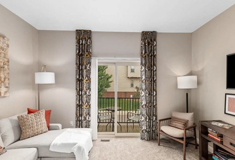 a living room with a couch and a door to a balcony