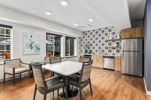A kitchen with a dining table and chairs.