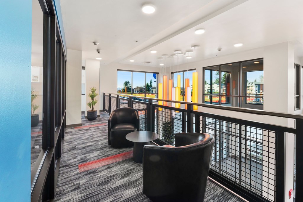 A modern office space with black chairs and a glass railing.