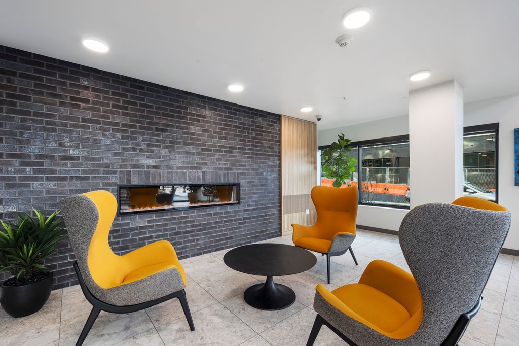 A grey and yellow chair is in front of a brick wall.