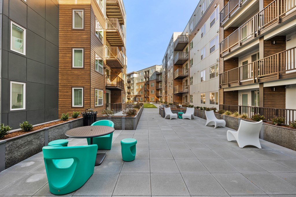 A modern outdoor seating area with green chairs and tables.