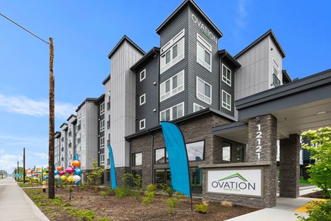 The image shows a modern building with the name "Ovation" on it.