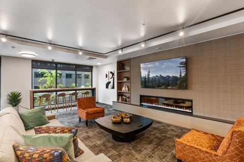 A living room with a fireplace and a painting of a mountain scene on the wall.