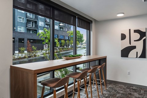 A kitchen with a table and chairs with a view of a street.