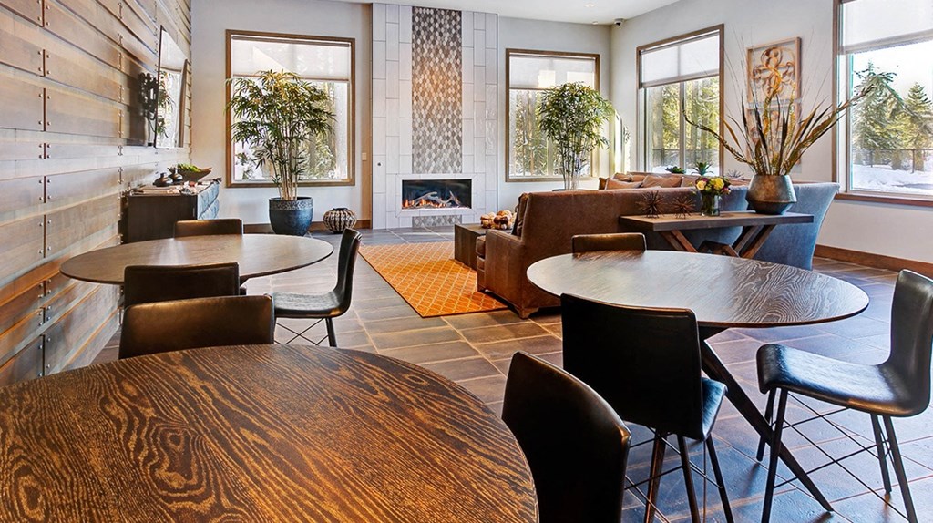 a living room with tables and chairs and a fireplace