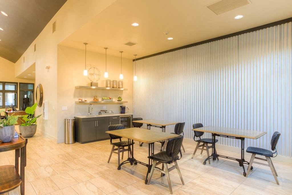 a dining room with tables and chairs and a kitchen