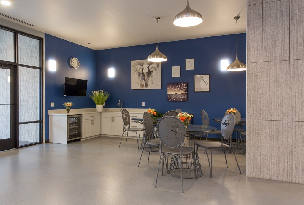 a dining room with a table and chairs in front of a blue wall