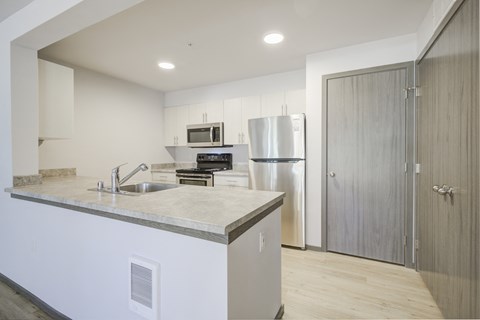 a kitchen with an island and a stainless steel refrigerator