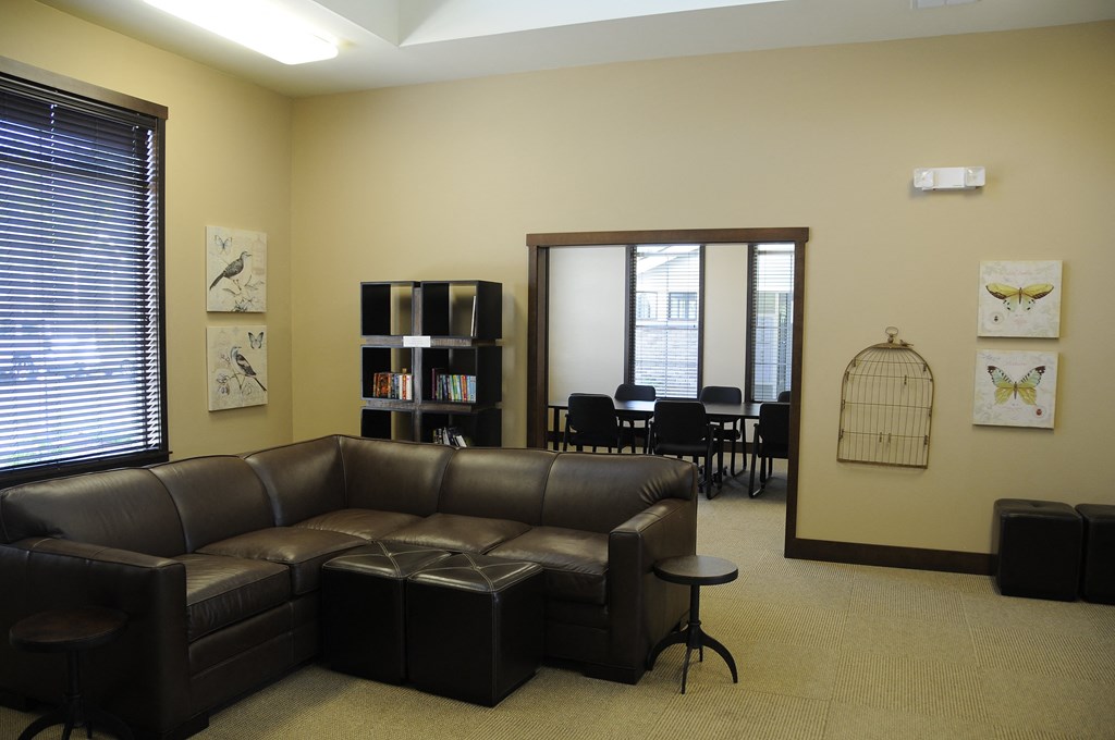 a living room with leather couches and a table and chairs