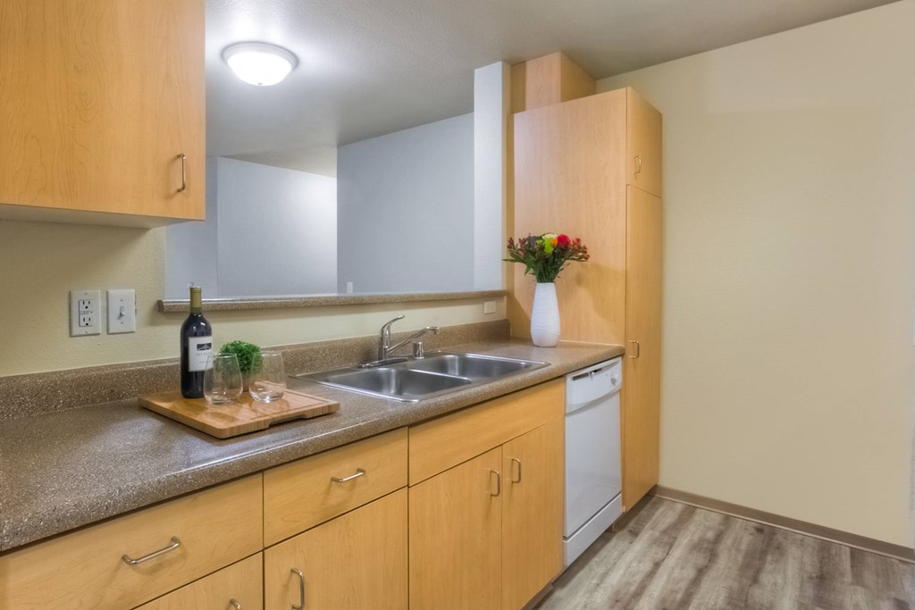 A kitchen with wooden cabinets and a granite countertop.