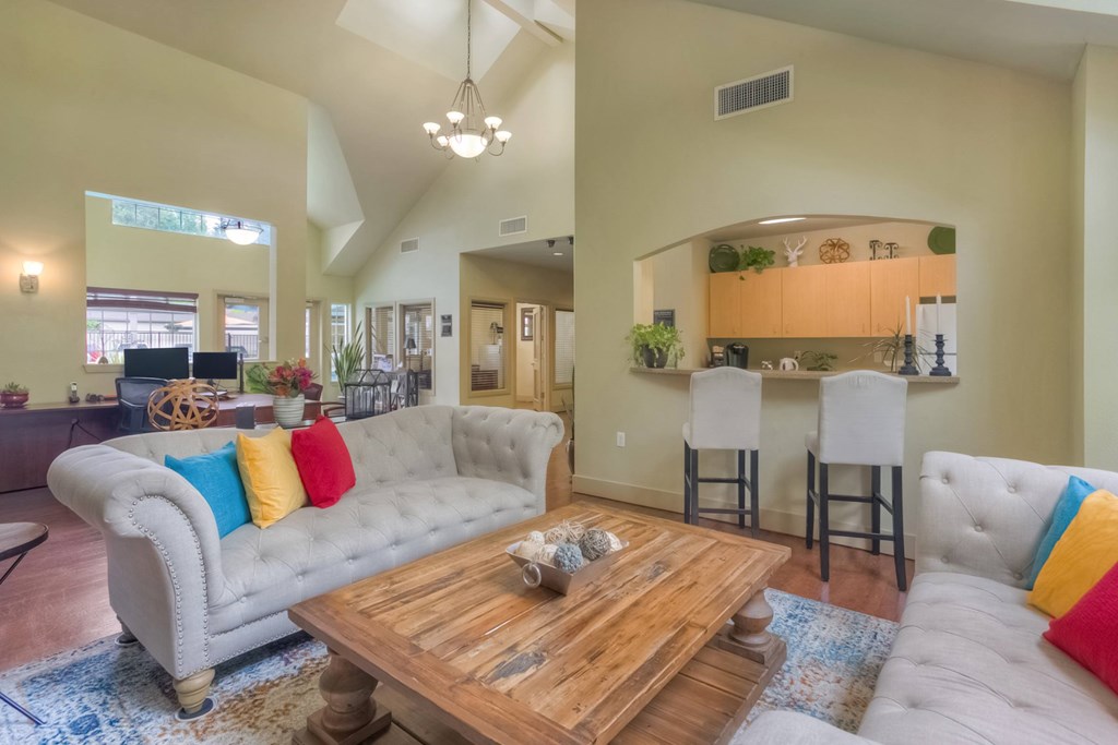A living room with a white couch and a wooden coffee table.