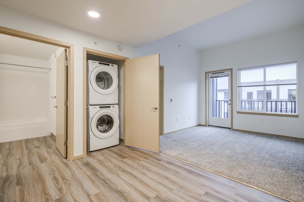 a washer and dryer in a room with a door to a laundry room at Ovation at Meeker, Kent, WA