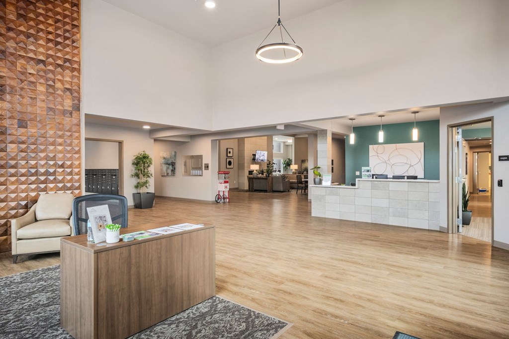A reception area with a wooden reception desk and a grey sofa.