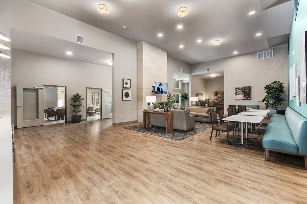 A spacious living room with a television, couches, and a dining table.