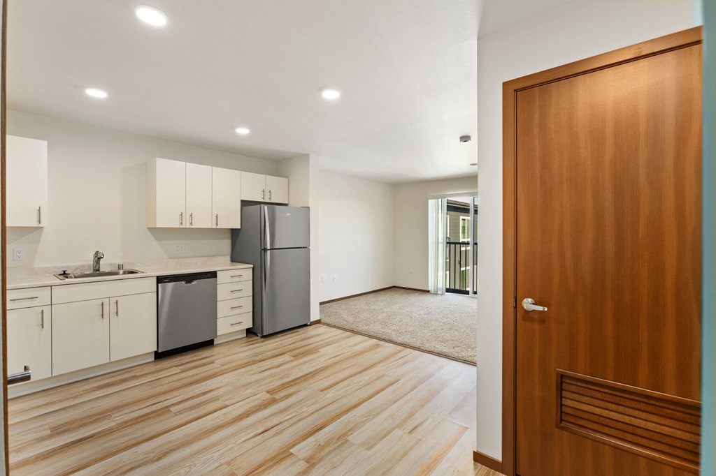 A kitchen with wooden floors and white walls.