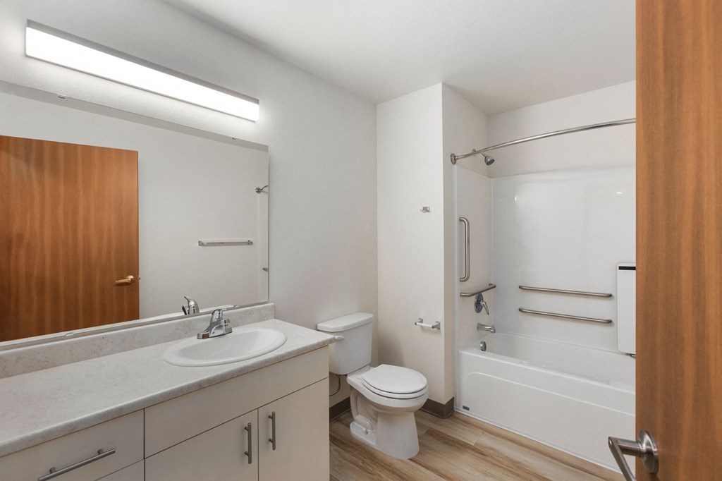 A white bathroom with a toilet, sink, and bathtub.