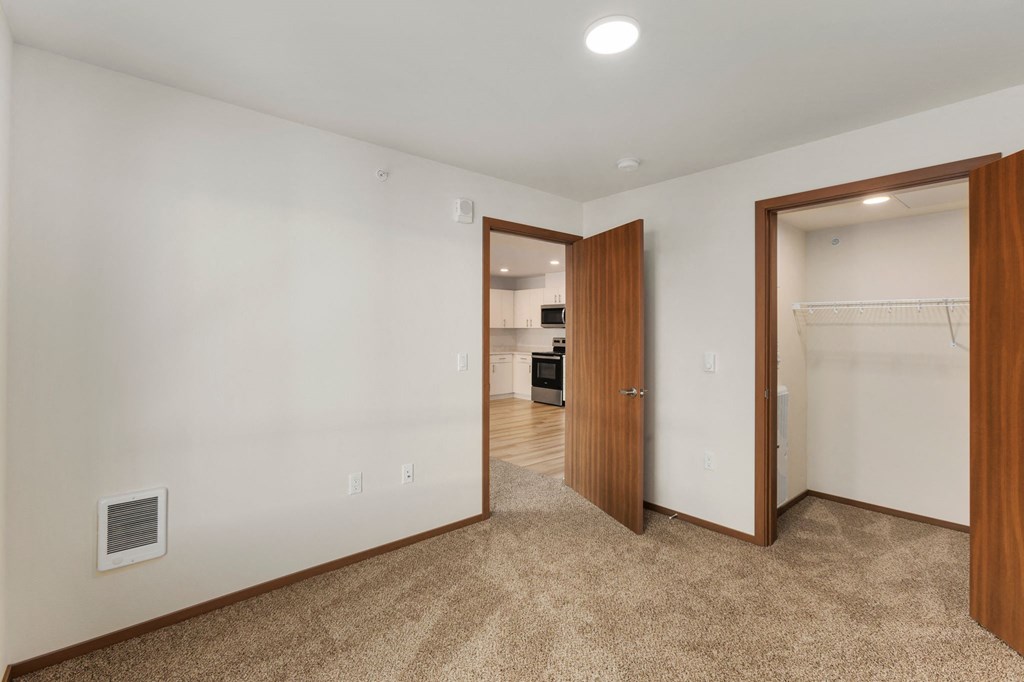 A room with a carpeted floor and a doorway leading to another room.
