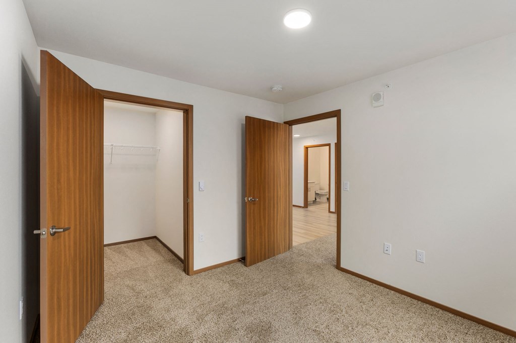 A room with two doors and a carpeted floor.