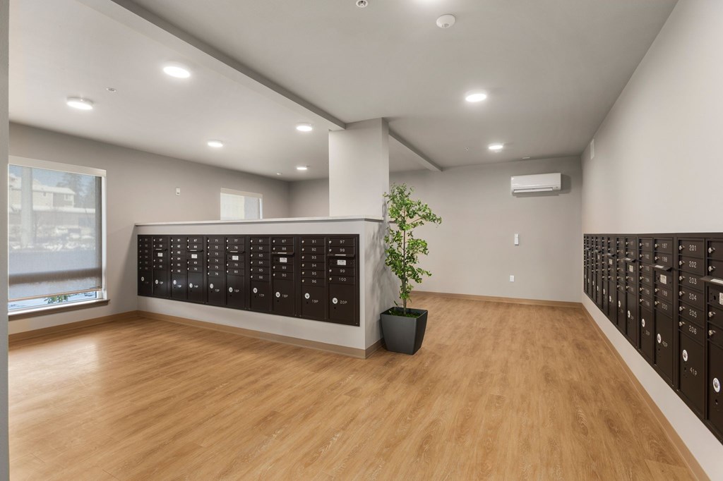 A room with wooden floors and a wall of black lockers.