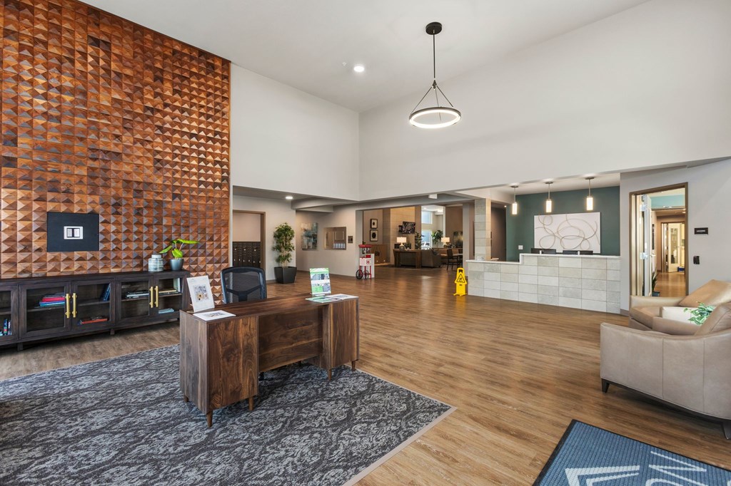 A reception area with a wooden wall and a black and white rug.