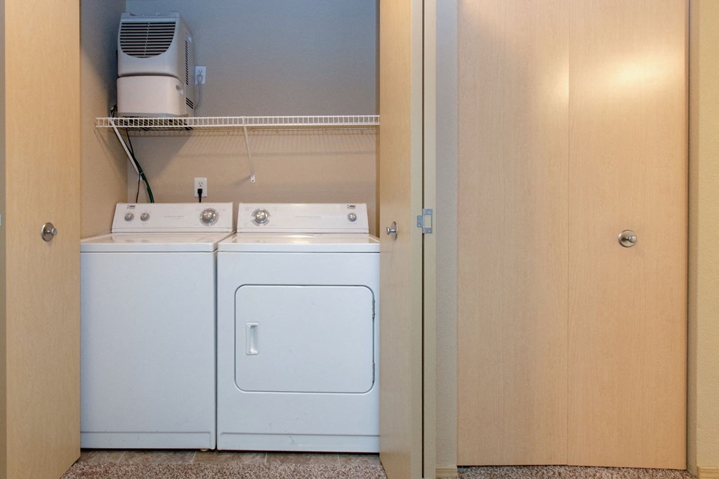 a washer and dryer in a closet next to a door