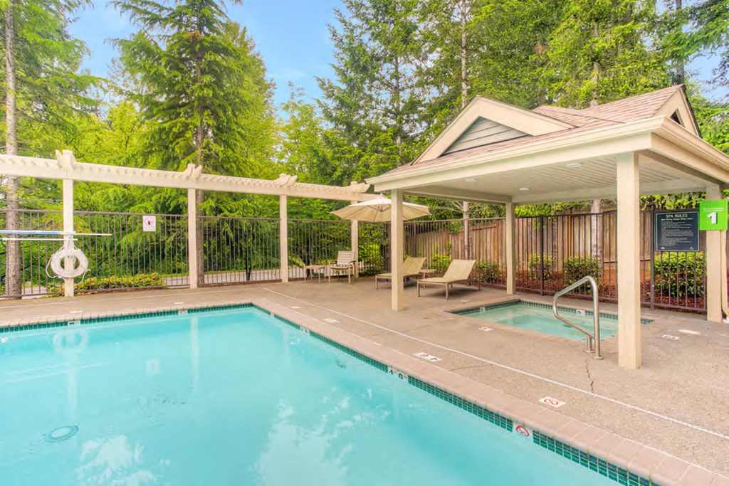 a swimming pool with a pavilion next to a resort style pool